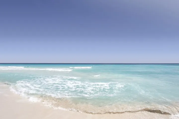 Oleaje turquesa sobre la arena en una playa de Cancún